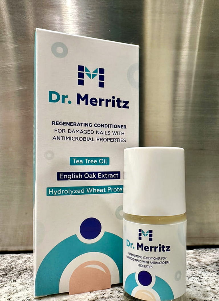 Opakowanie i buteleczka Dr. Merritz stojące na blacie przy stalowej ścianie