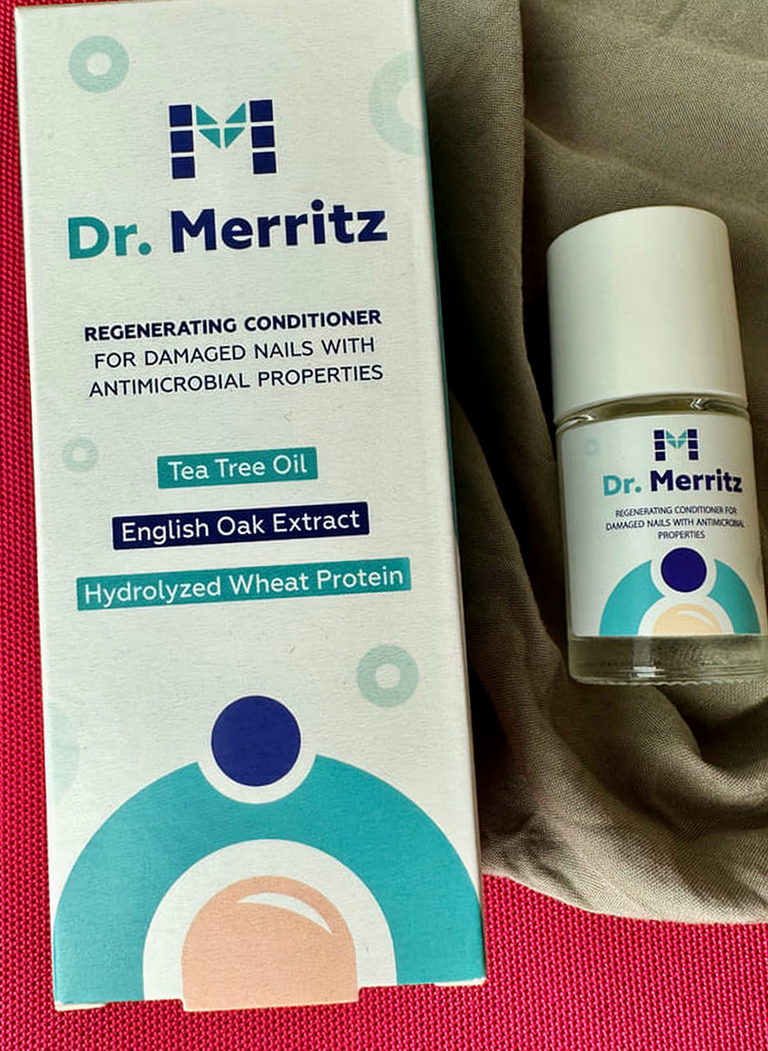 Kartonik i buteleczka Dr. Merritz na różowej tkaninie i materiale khaki